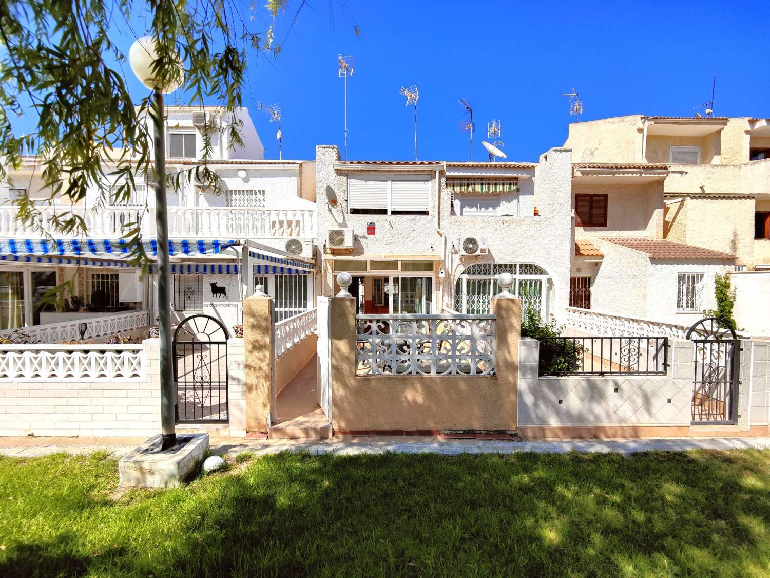 ENCANTADORA CASA ADOSADA DE DISEÑO MEDITERRÁNEO CON DOS DORMITORIOS, JARDÍN DELANTERO Y TRASERO EN URB. LA FIESTA III